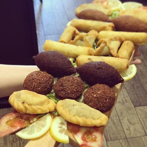 Plateau de beignets libanais servis sur planche — kebbé, falafel, samboussek et fatayer